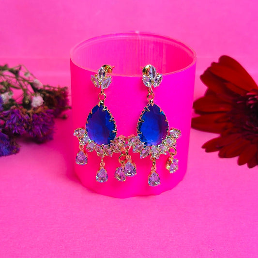 Blue earrings with pink candle on a pink background